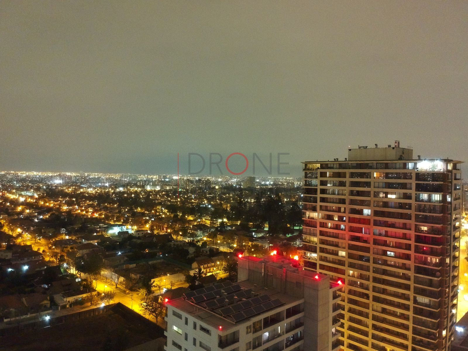 Ciudad de noche con torre de departamentos