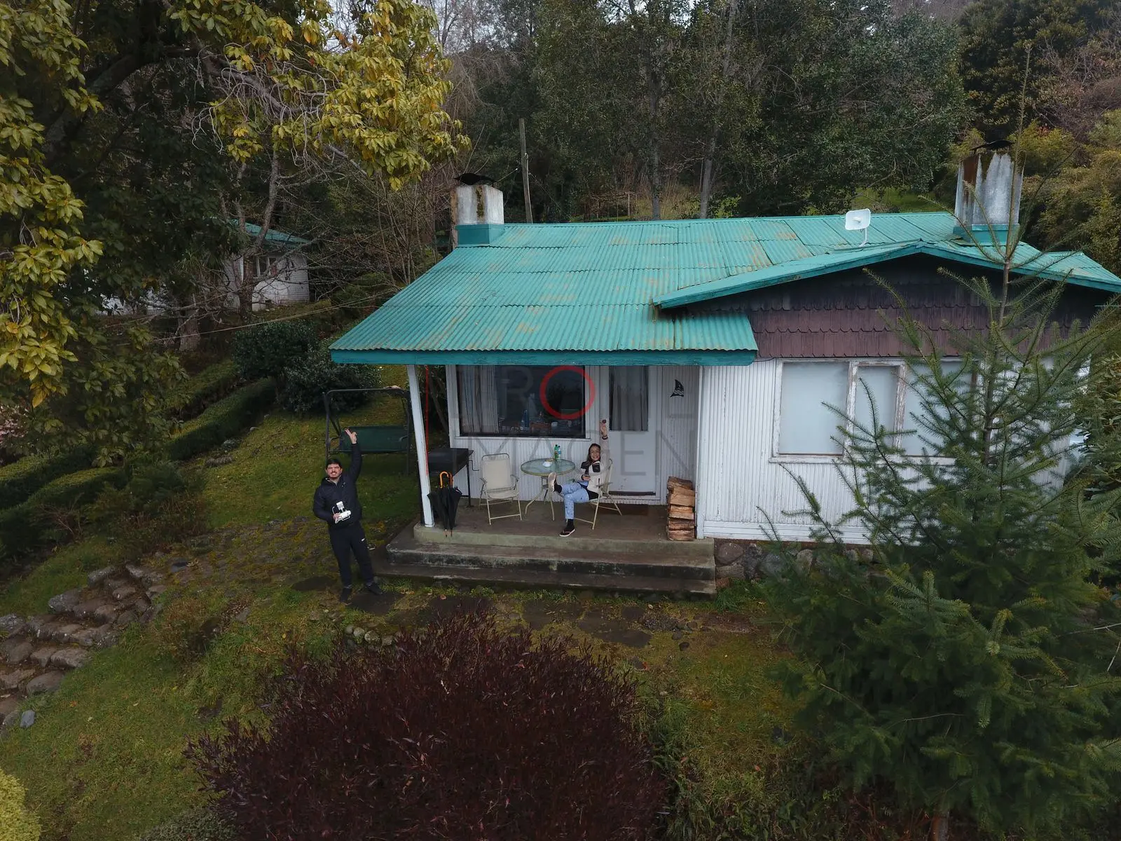 Casa con techo turquesa y personas, lago Ranco