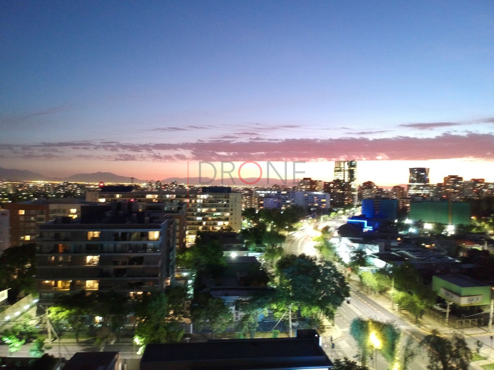 Edificios iluminados y horizonte rosado, Las Condes