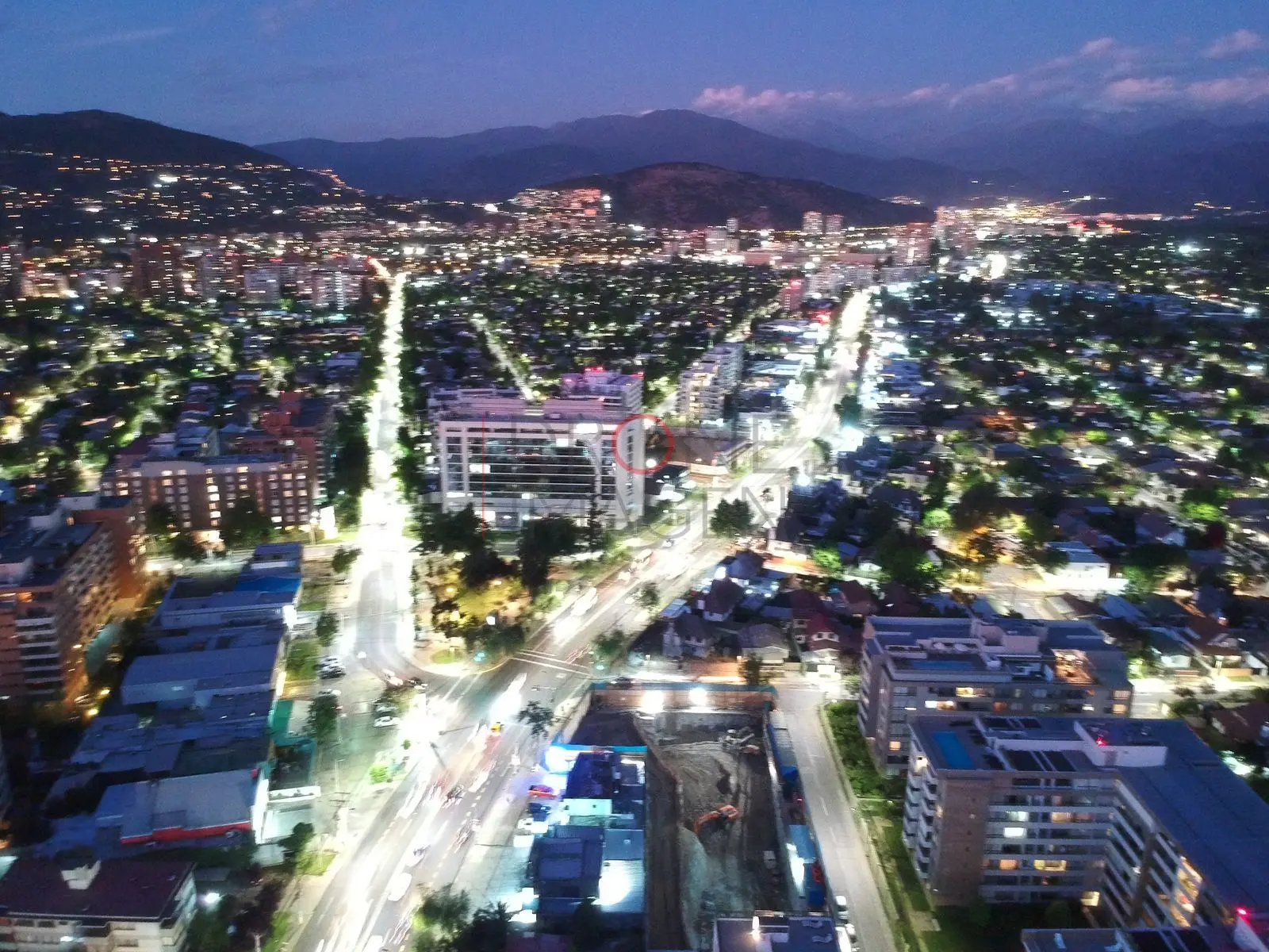 Avenida principal iluminada de noche, Las Condes · vista aérea oblicua
