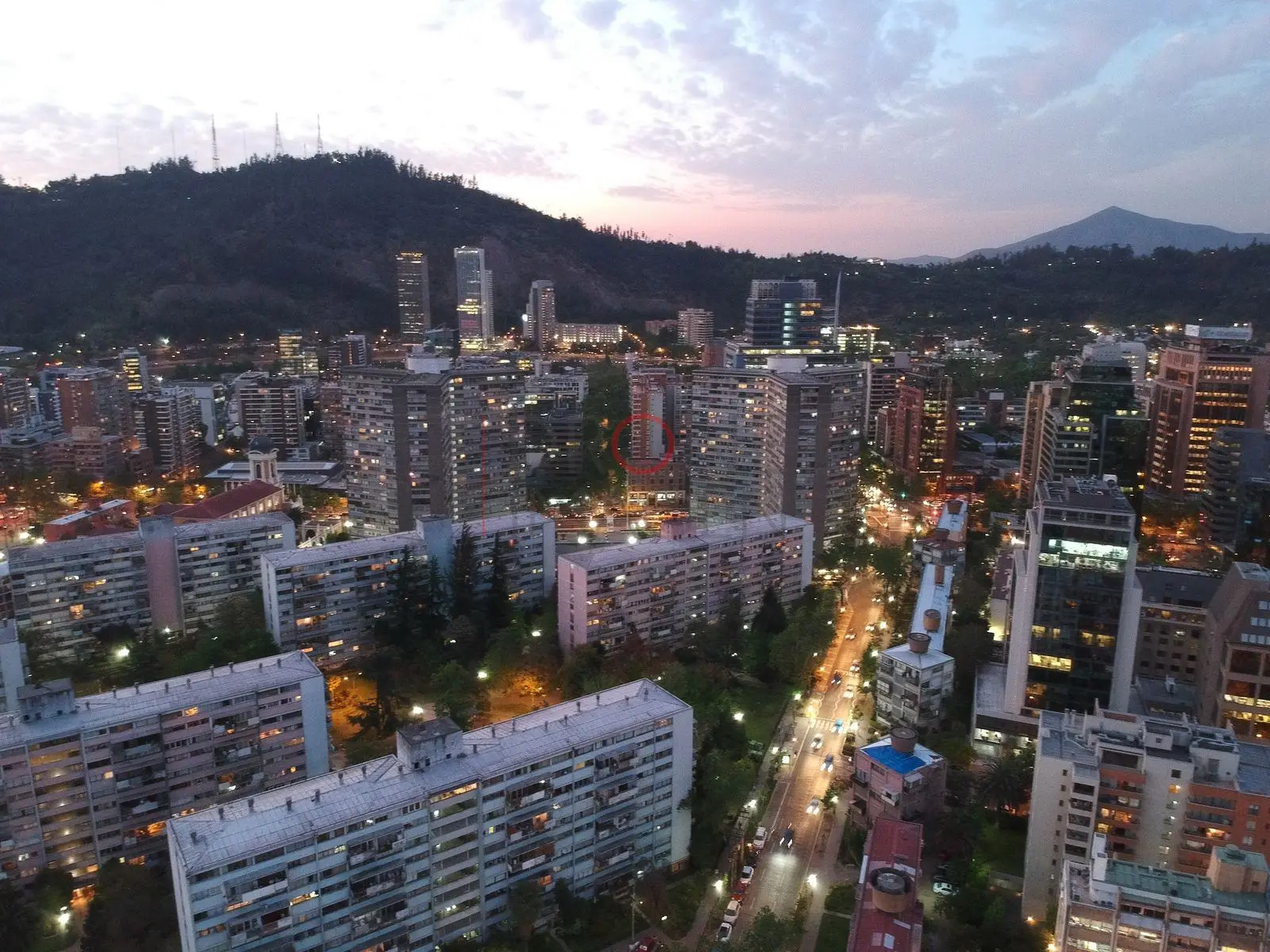 Bloques de departamentos y cerro al anochecer, Providencia · vista aérea oblicua