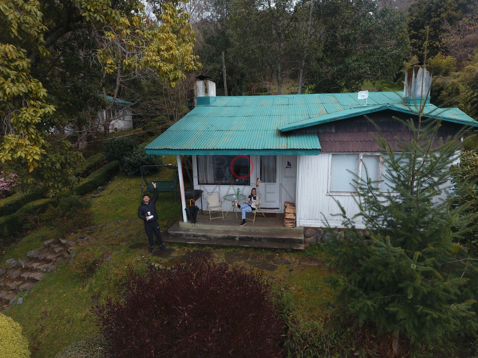 Casa con techo turquesa y personas, lago Ranco (2)