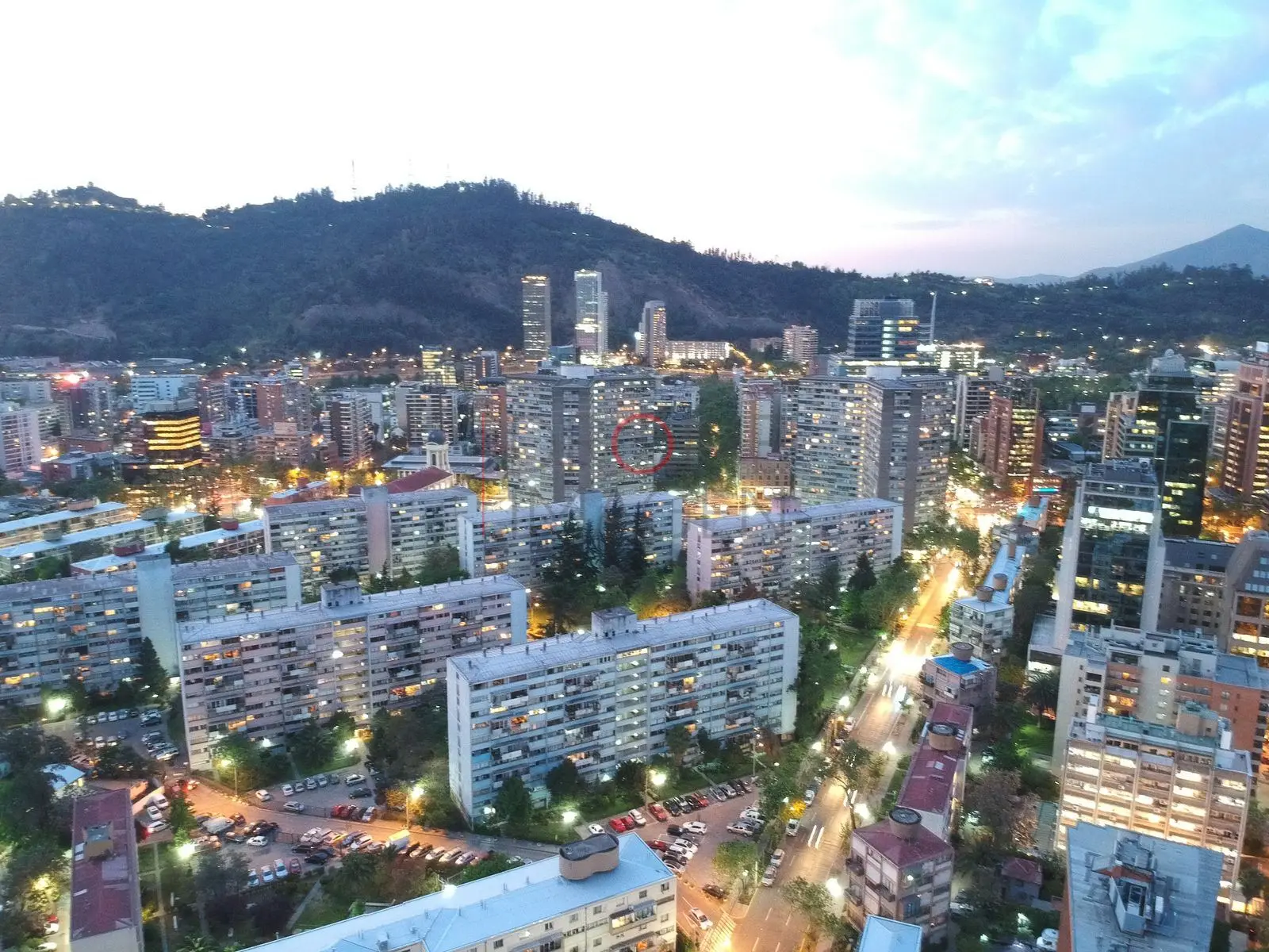 Departamentos y cerro con luces de la ciudad, Providencia · vista aérea oblicua