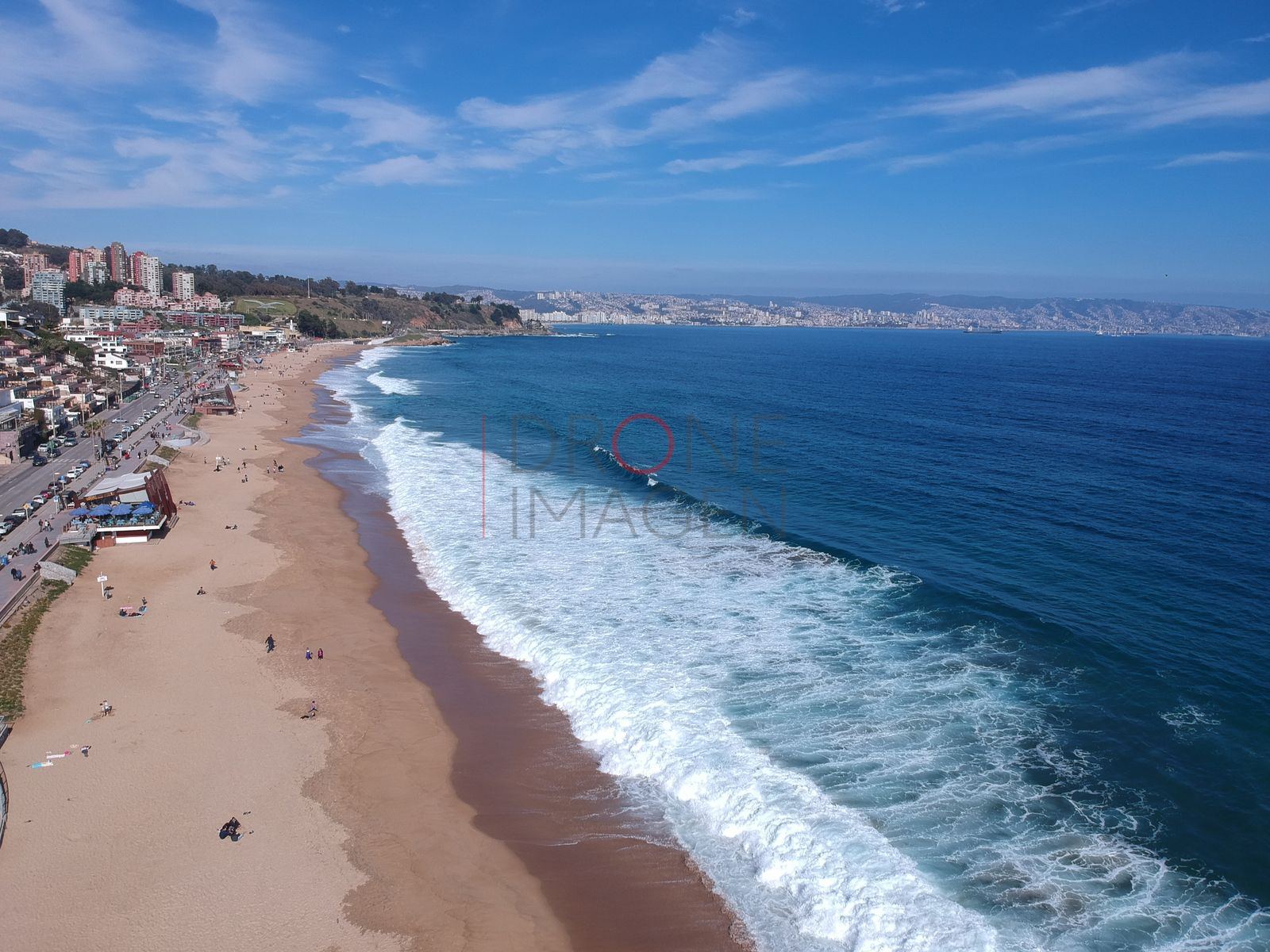 Playa y oleaje azul frente a la ciudad, Reñaca