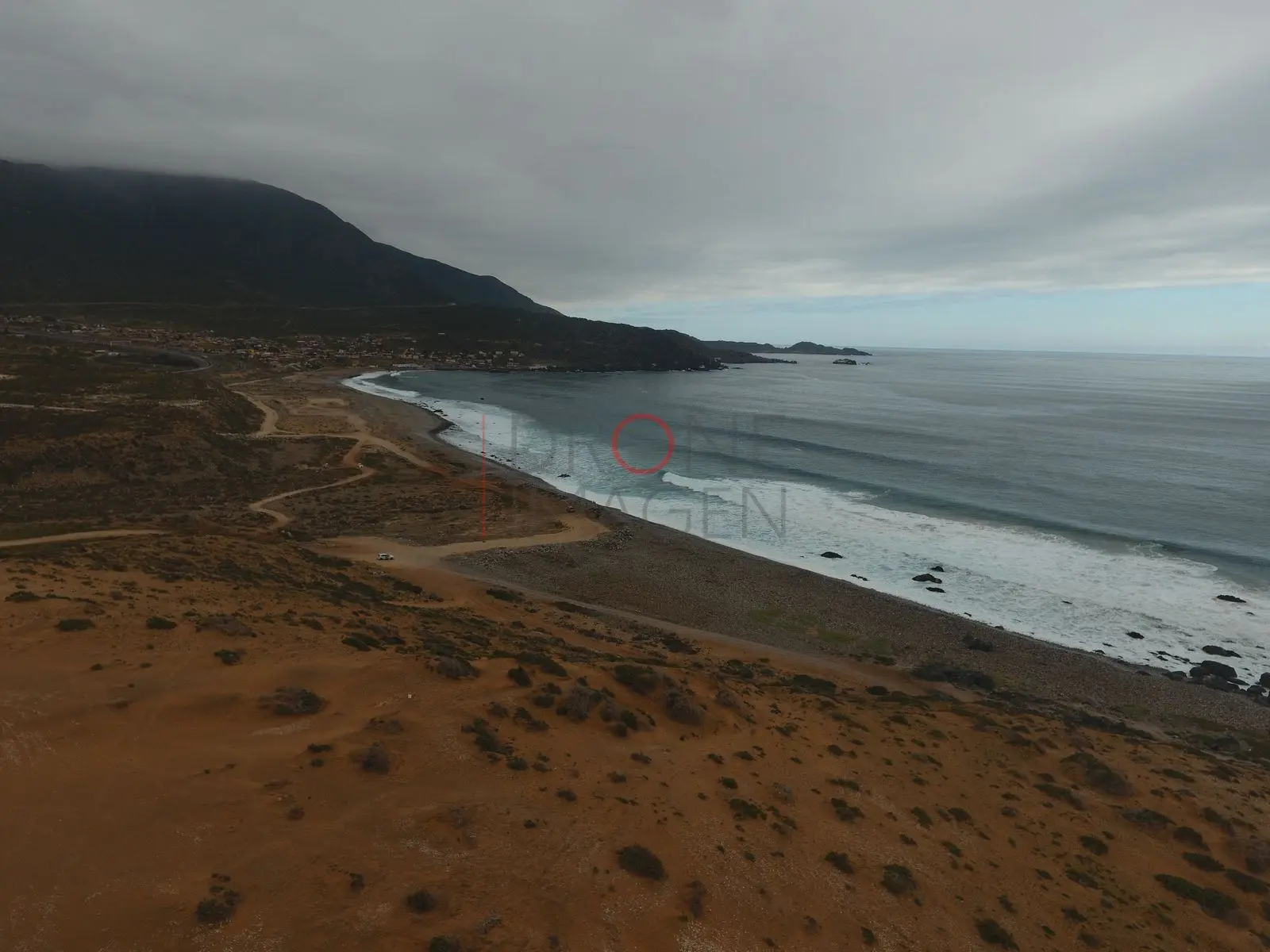 Costa desértica con oleaje bajo cielo nublado, Caleta Hornos