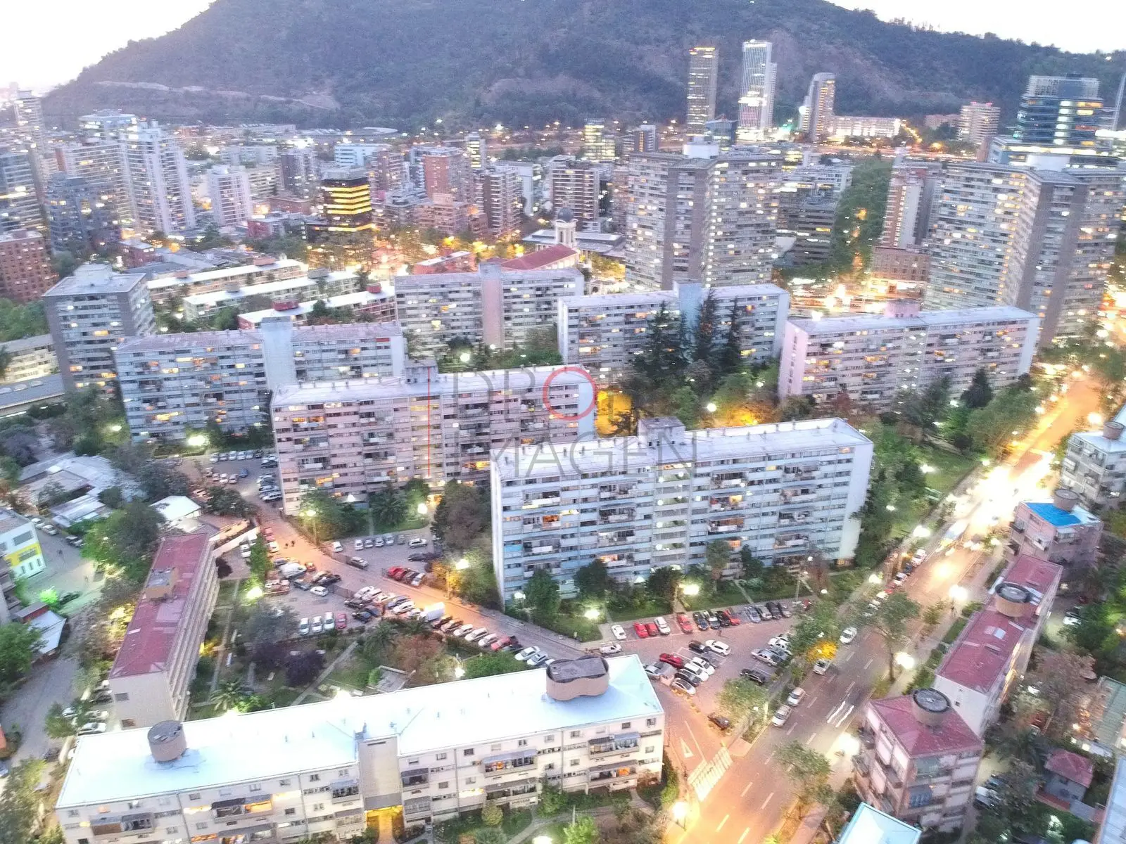 Bloques de departamentos y calle iluminada, Providencia · vista aérea oblicua