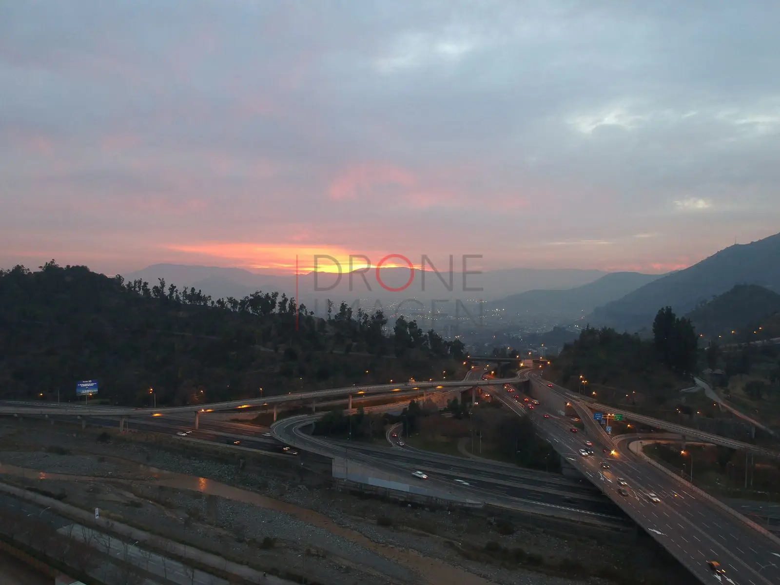 Atardecer sobre autopistas y precordillera, Vitacura · vista aérea oblicua