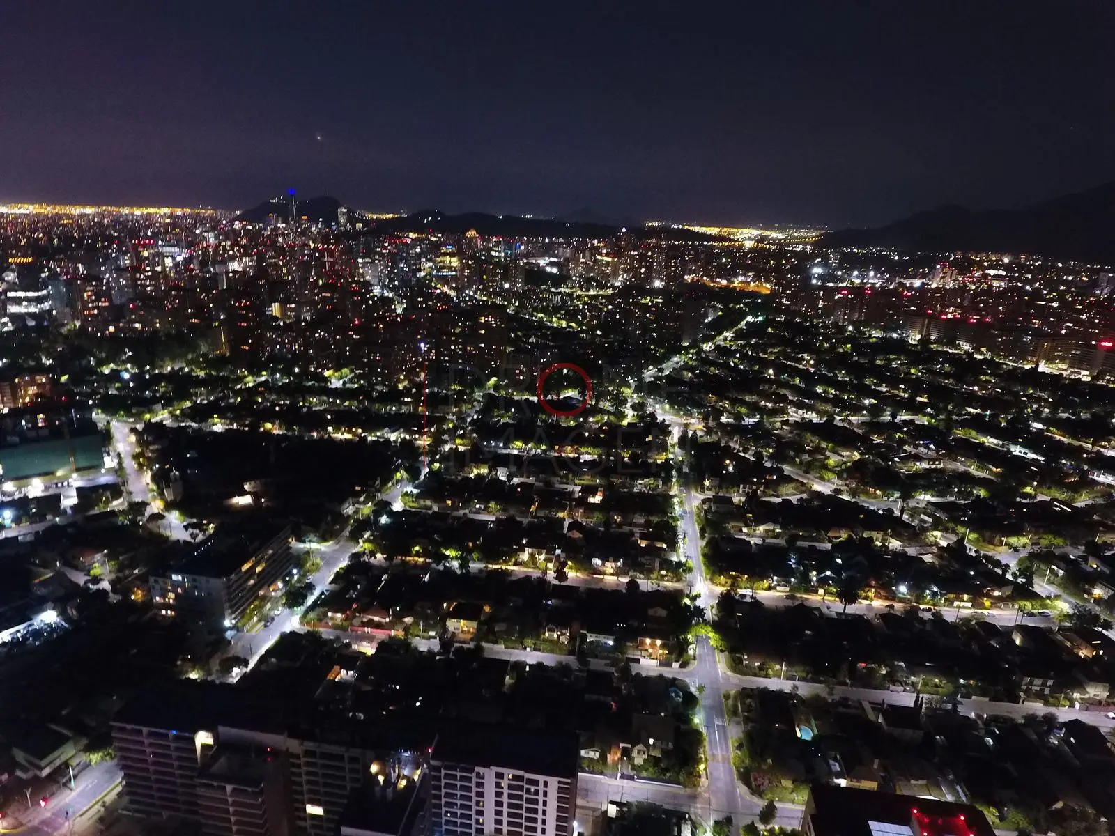Ciudad iluminada bajo un cielo violeta, Las Condes · vista aérea oblicua