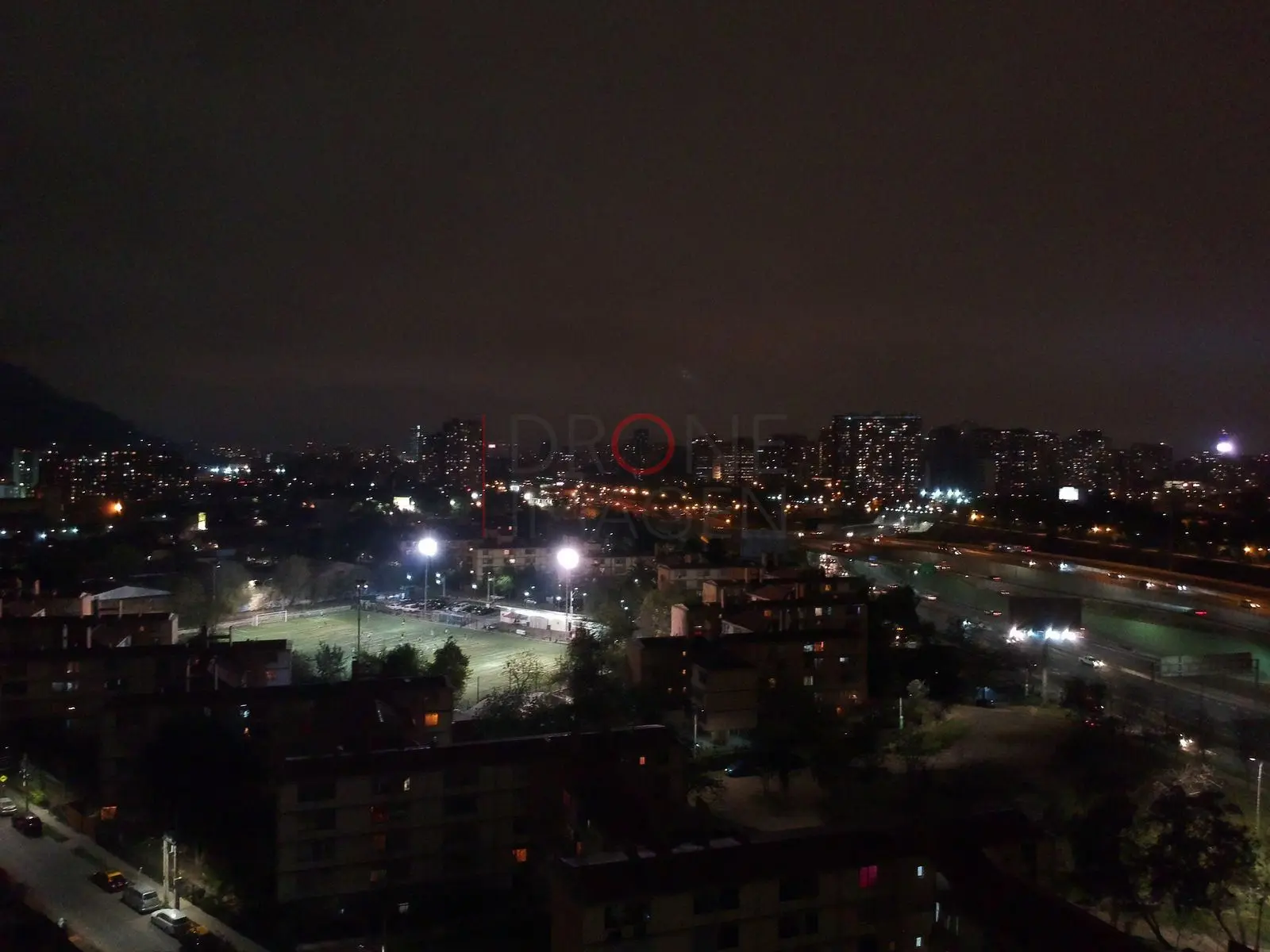 Cancha iluminada y ciudad de noche, Independencia — Santiago, Chile