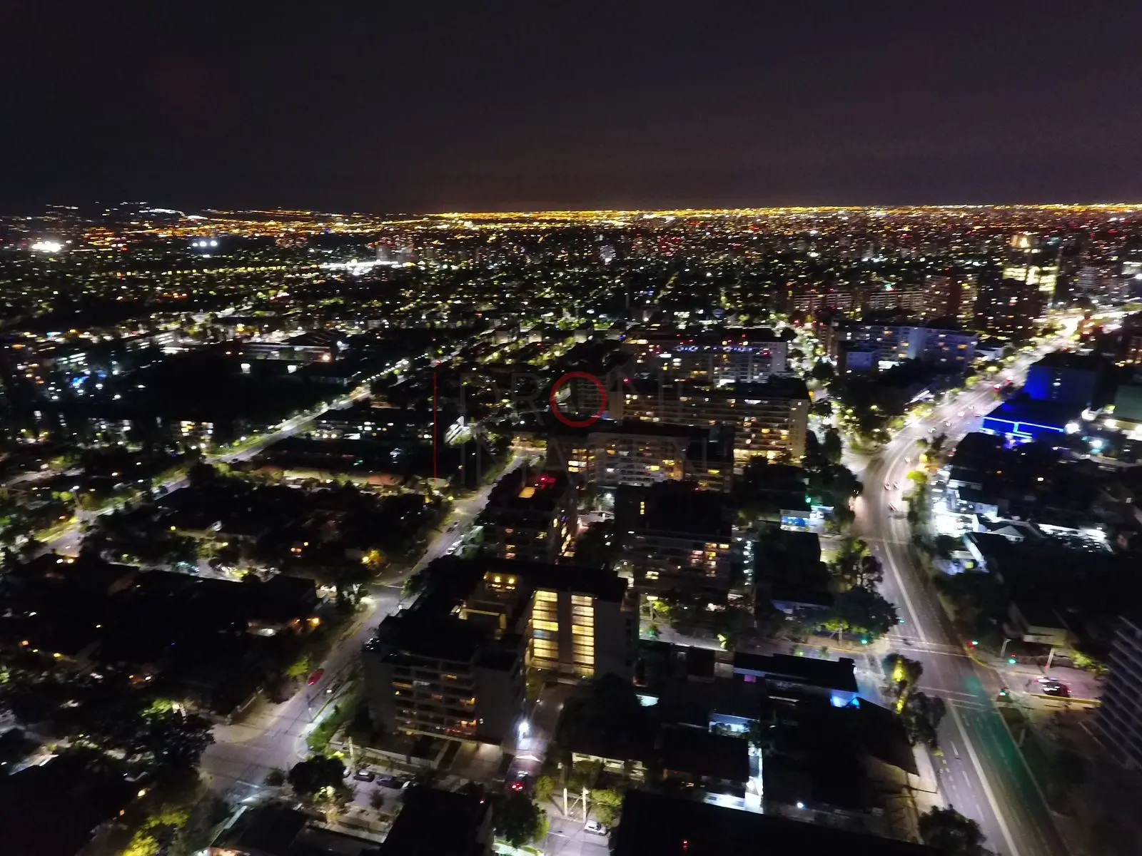 Ciudad de noche y horizonte anaranjado, Las Condes · vista aérea oblicua