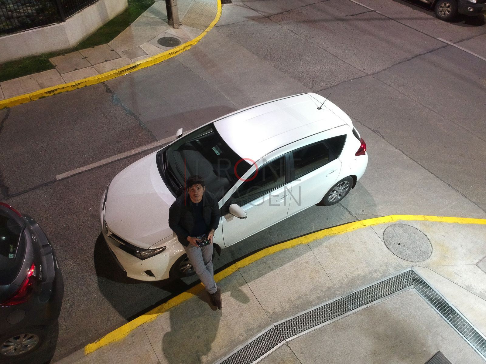 Auto blanco y persona en un estacionamiento, Las Condes