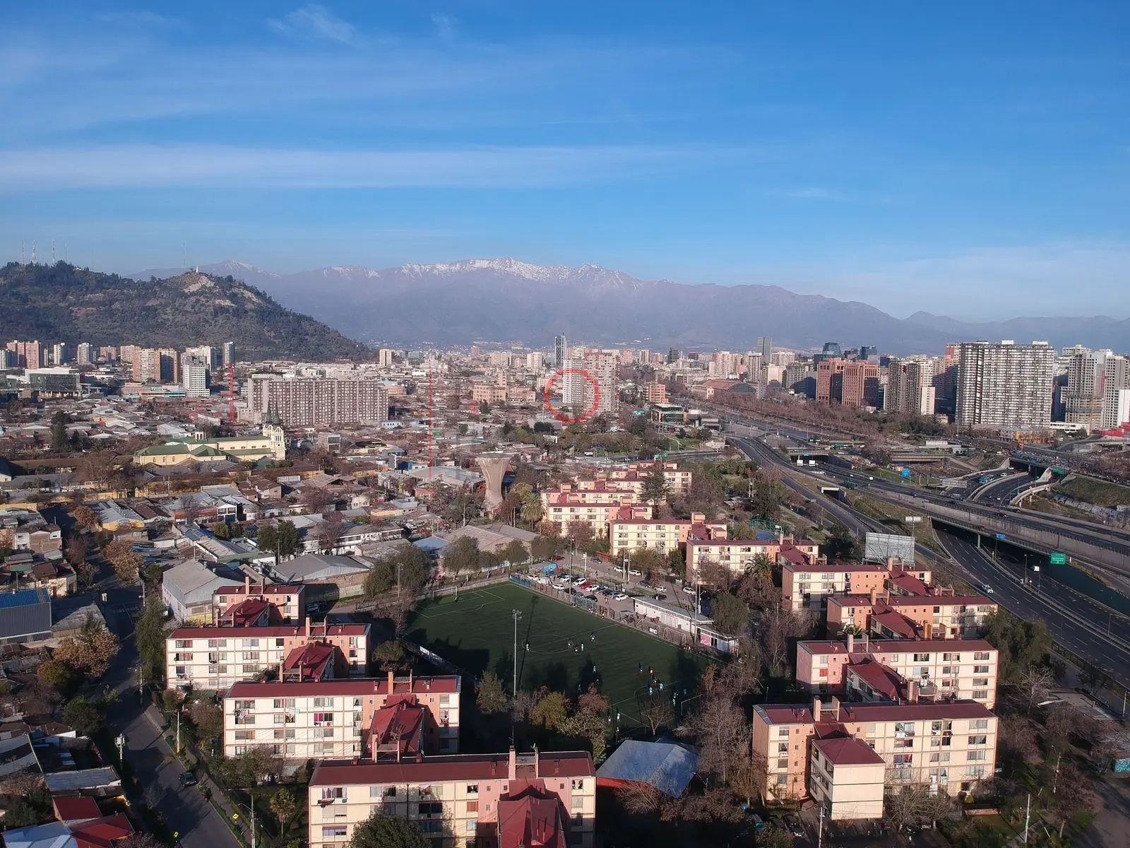 Blocks y cancha de fútbol frente a la cordillera, Independencia · vista aérea oblicua