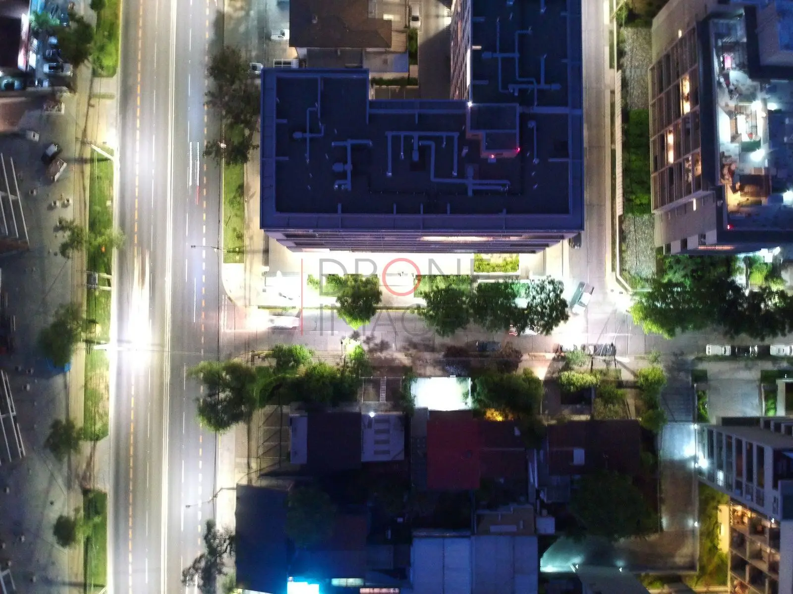 Edificio y avenida iluminados, Las Condes · vista cenital