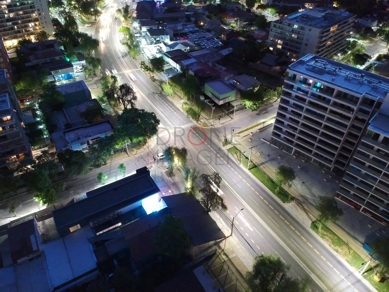 Avenida iluminada entre edificios, Las Condes · vista cenital