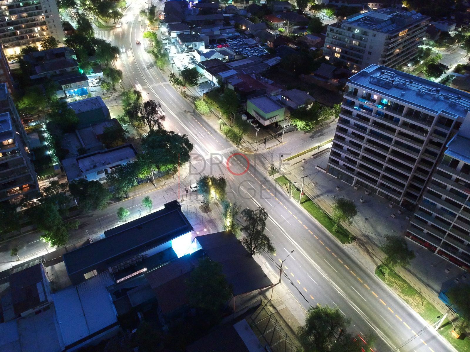 Edificio de departamentos y calles en hora azul, Las Condes