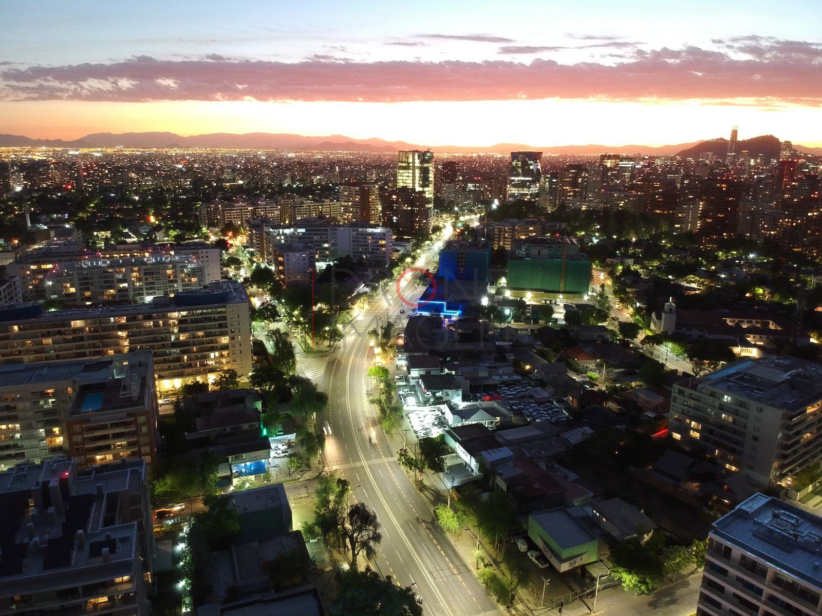 Avenida iluminada bajo cielo de atardecer, Las Condes