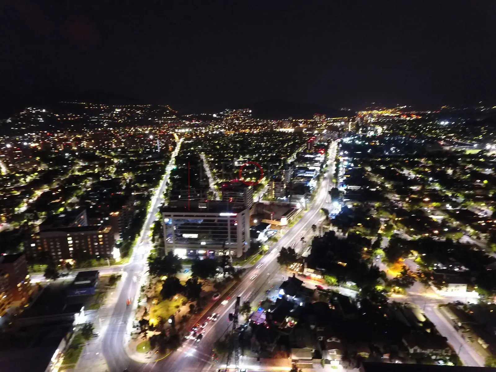 Ciudad iluminada y avenida de noche, Las Condes · vista aérea oblicua