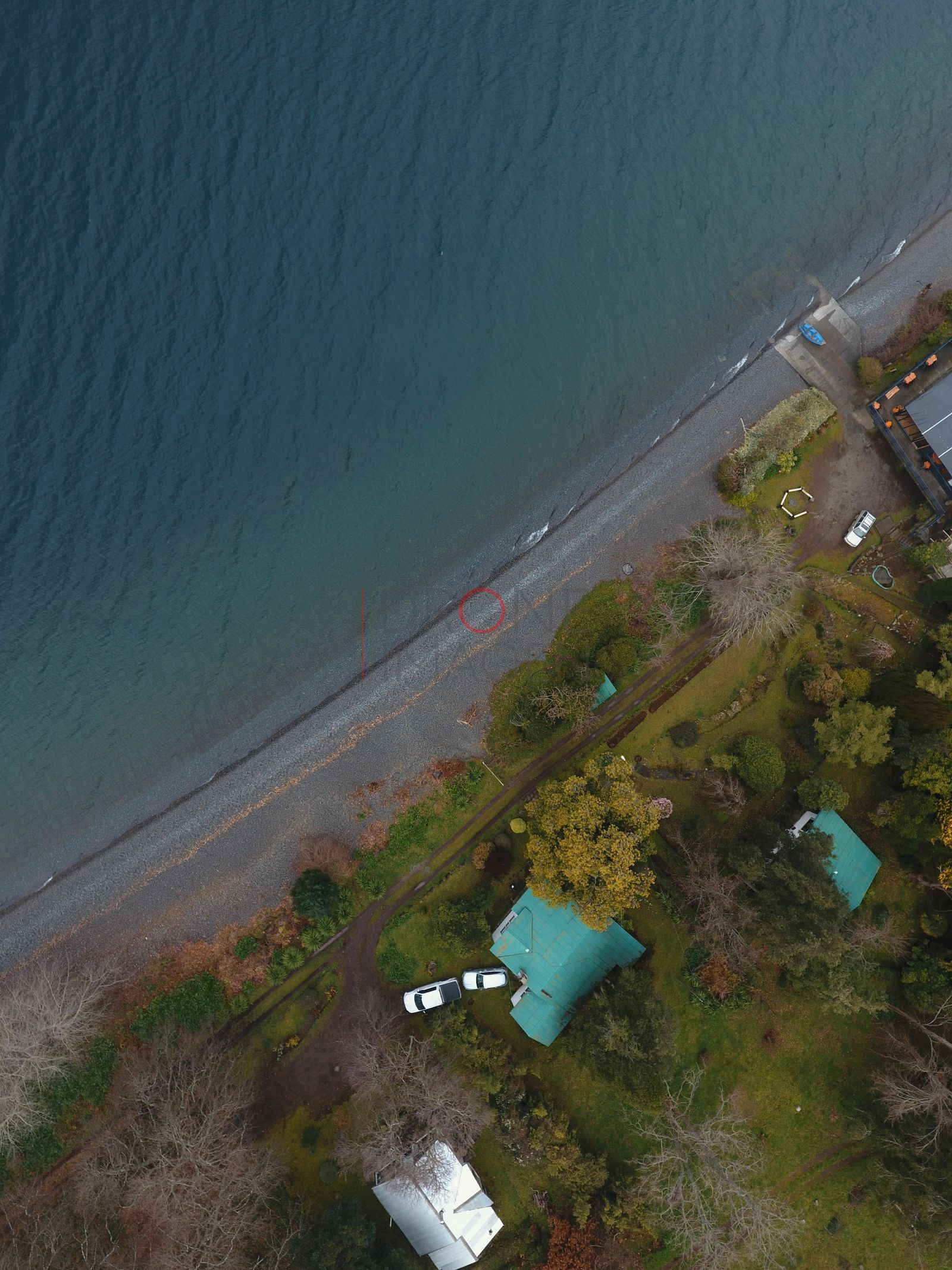 Costa del lago Ranco con casas y sendero de arena