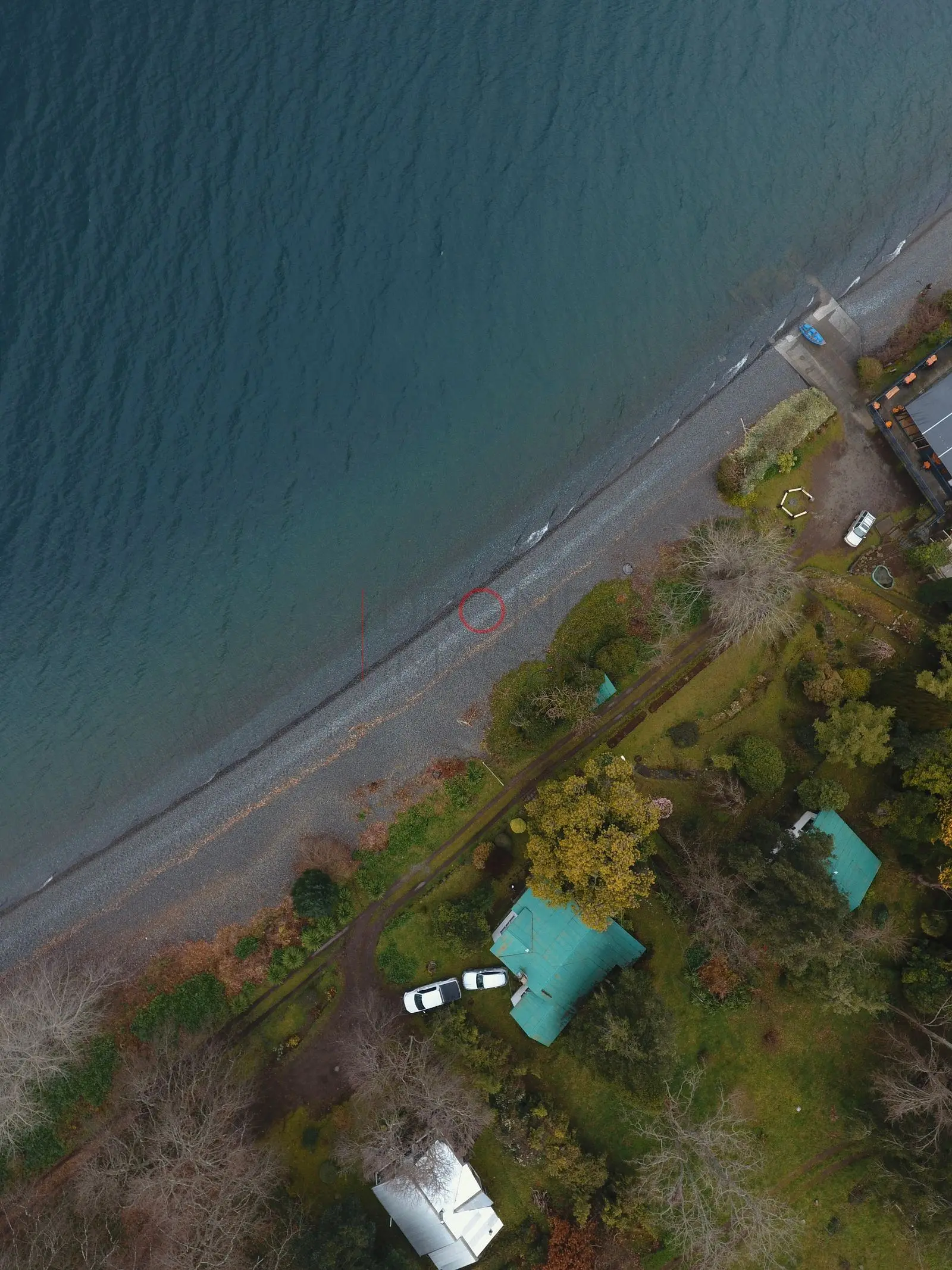 Costa del lago Ranco con casas y sendero de arena