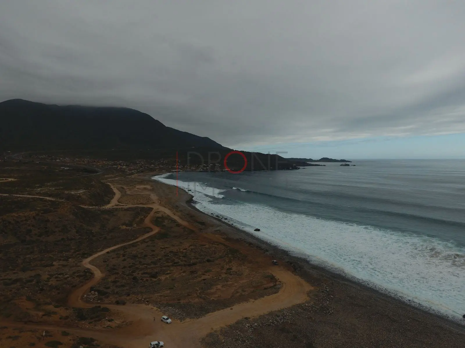 Playa solitaria y camino de tierra junto al mar, Caleta Hornos