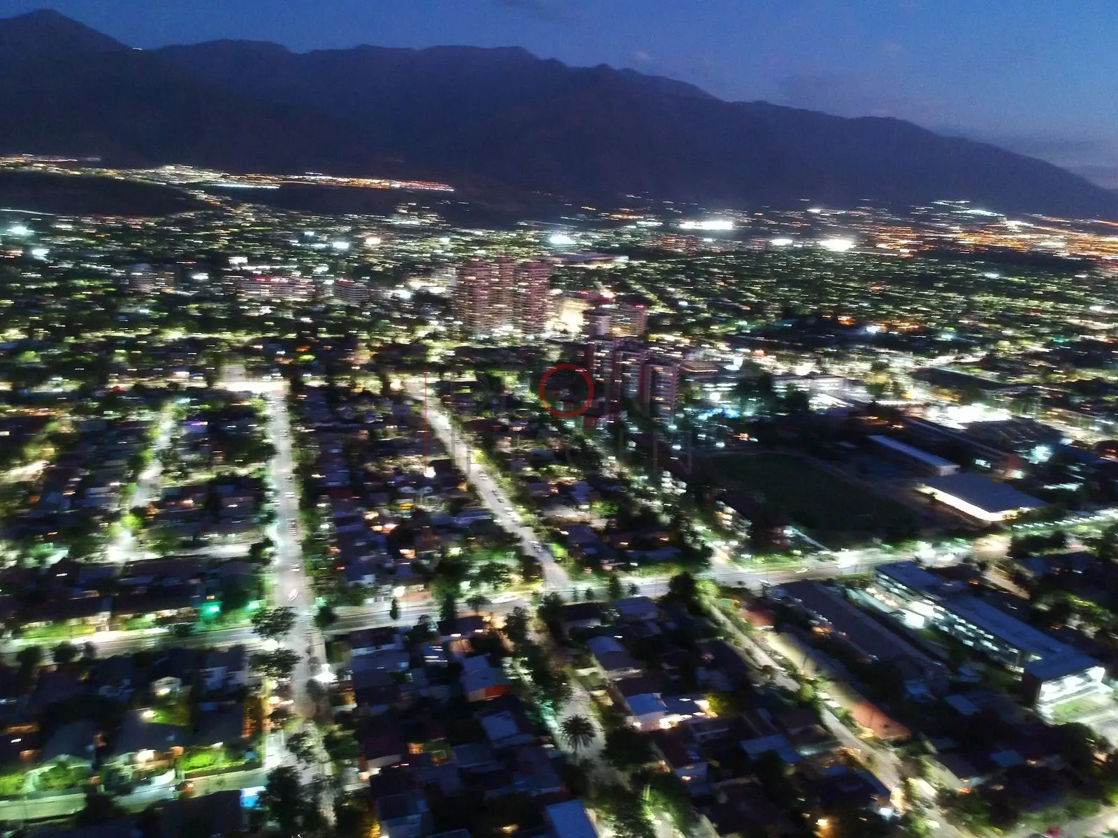 Calles iluminadas y cordillera al anochecer, Las Condes · vista aérea oblicua