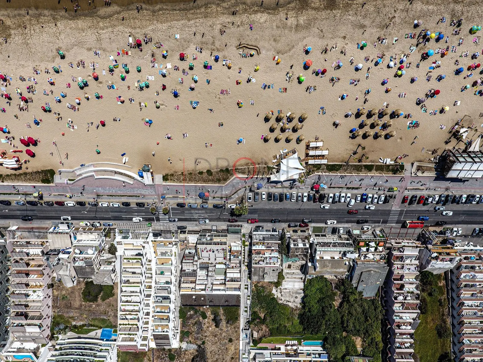 Playa concurrida y avenida costera